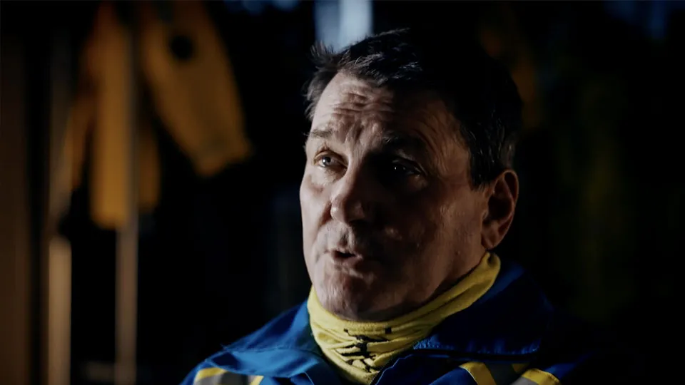 A Coastguard Rescue Officer sits facing the camera