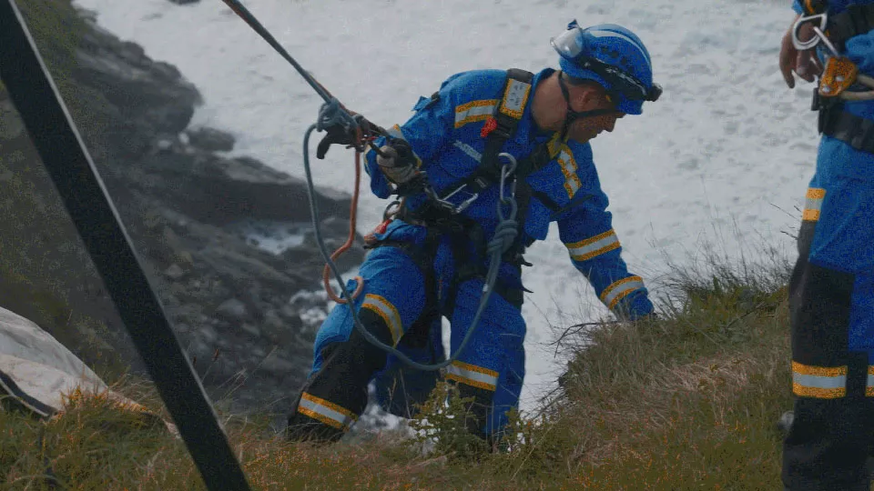 A coastguard rescue officer performing a cliff rescue