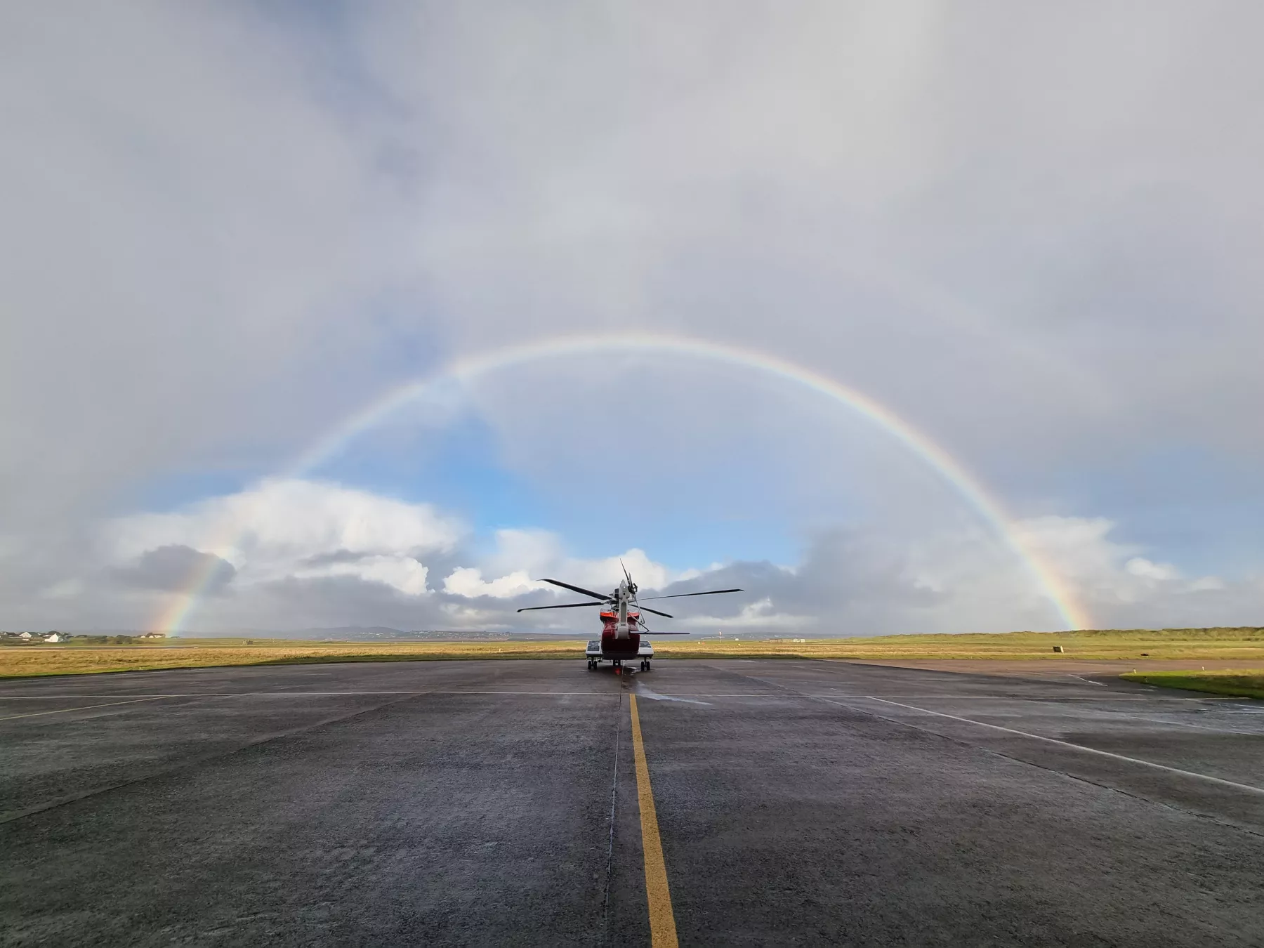 Rainbow over coastguard helicopter on Stornoway runway